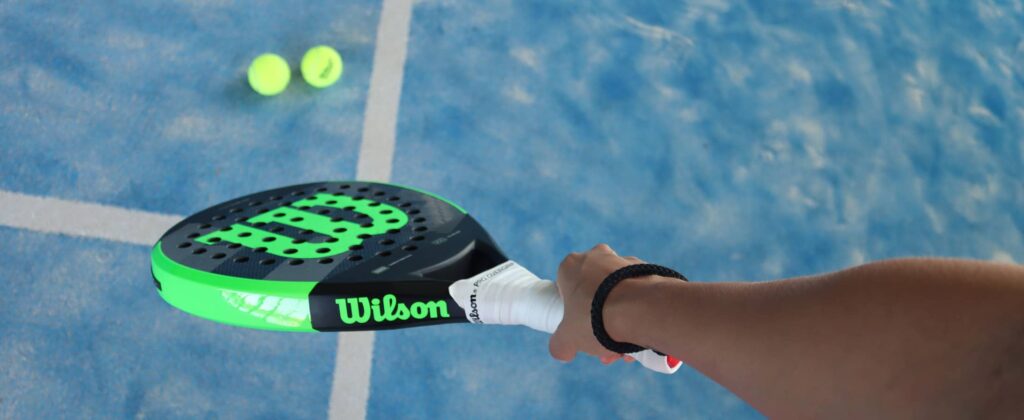 Foto van een padel racket met bescherming en een persoon die de racket vastheeft