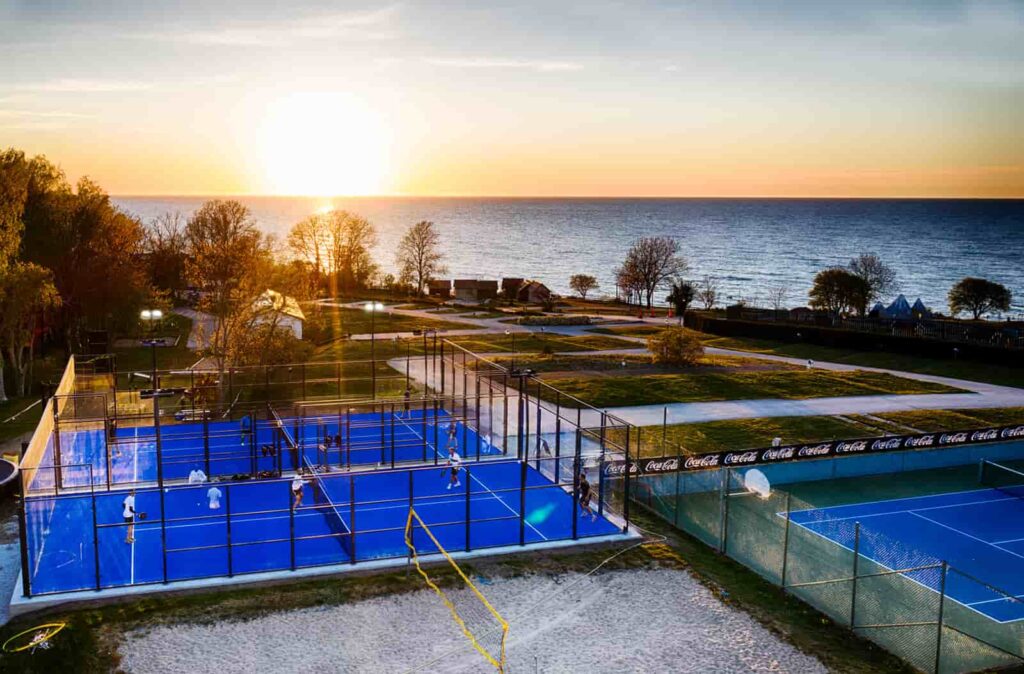 Kneippbyn padelbaan van boven genomen waarbij de kust goed zichtbaar is en een tennisbaan ernaast
