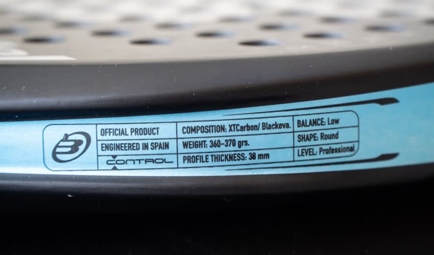 Close-up foto van een padel racket etiket waar het gewicht en de milimeters op staan